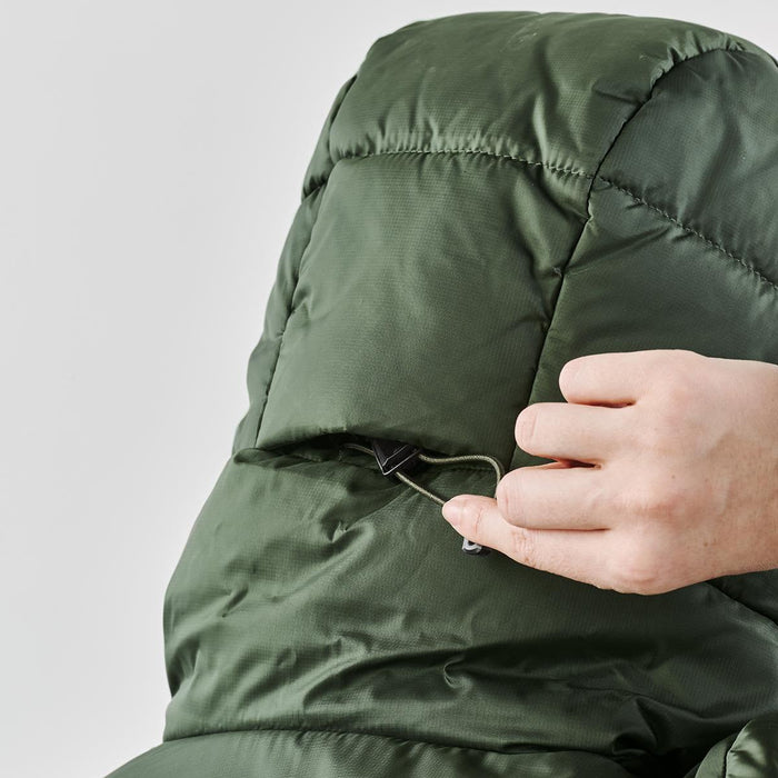 Women's Elkridge Parka - A close-up of a hand adjusting the hood of a green puffer jacket, featuring a logo on the back.
