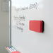 Magnetic Foam Whiteboard Eraser - A magnetic foam whiteboard eraser in red and black, positioned on a whiteboard beside written notes.