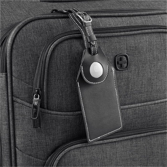 Wander & Roam Luggage Tag w/ AirTag Holder - A black luggage tag with an AirTag holder attached to a grey suitcase, featuring a logo on the suitcase.