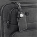 Wander & Roam Luggage Tag w/ AirTag Holder - A black luggage tag with an AirTag holder attached to a grey suitcase, featuring a logo on the suitcase.